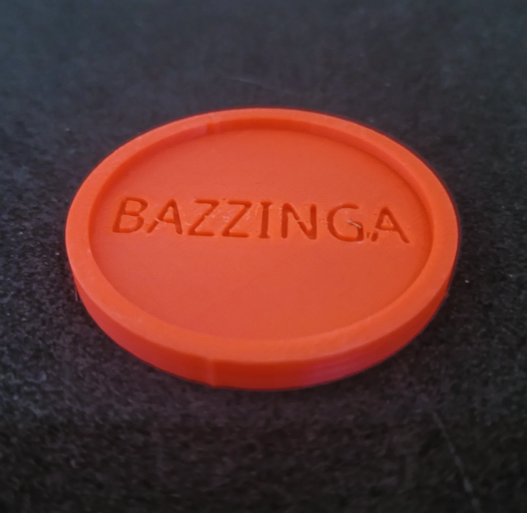 A glass coaster, with the word "Bazzinga