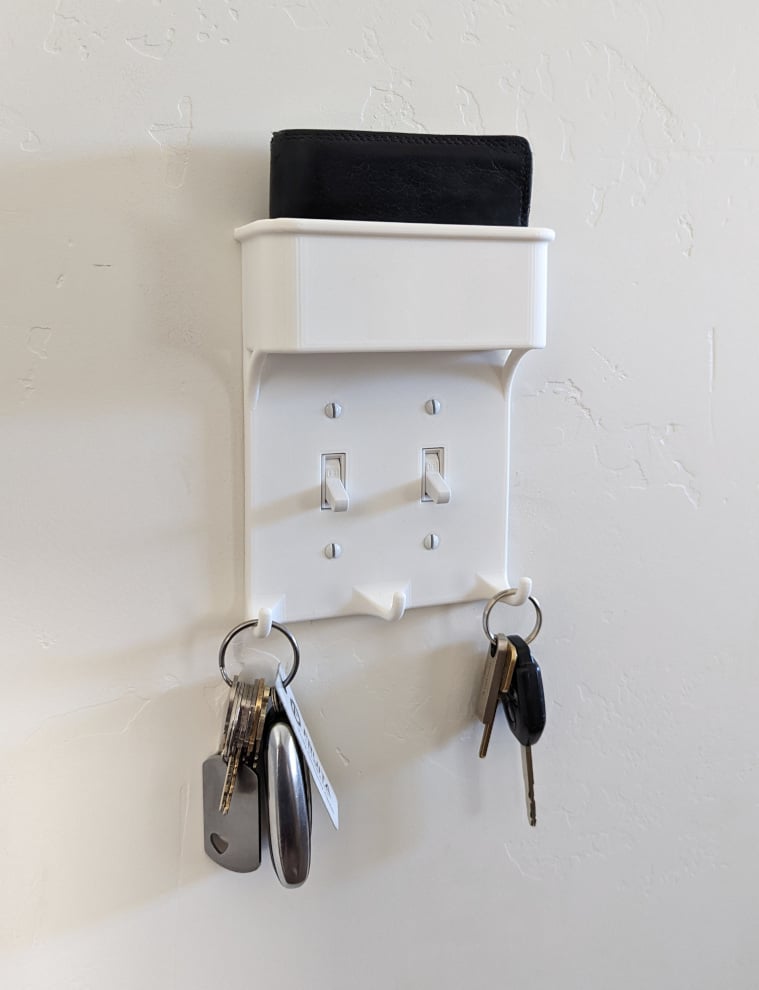 Light switch plate with key hooks and wallet pocket