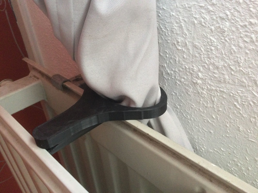 Curtain holder which clips onto a radiator