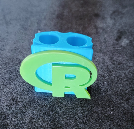 A pen holder, with the symbol of the R programming language