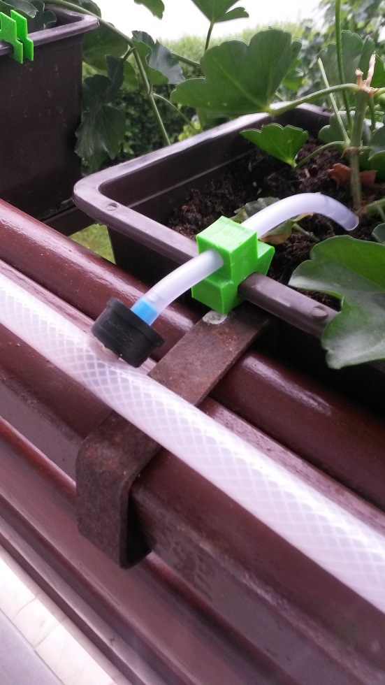 Plastic flower box irrigation tube holder