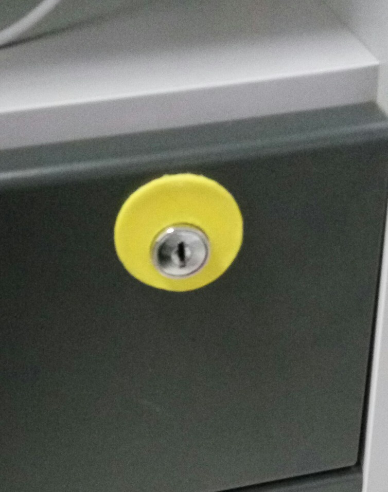 Off-center cover for drawer lock