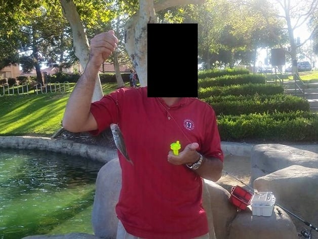 Man holding fish caught with 3d printed fishing reel